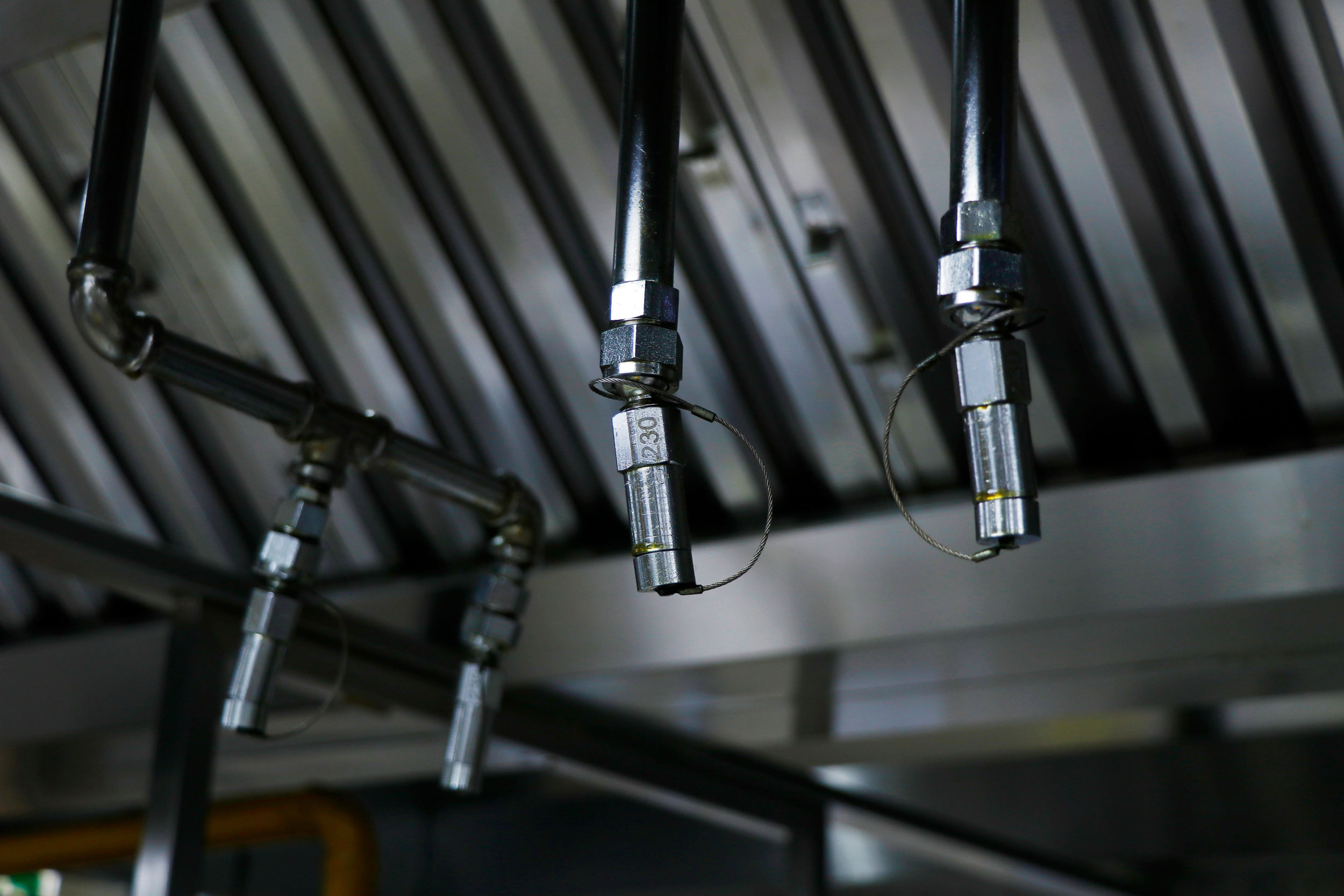 Kitchen hood suppression system nozzles inspected above commercial cooking equipment in Southeast Missouri